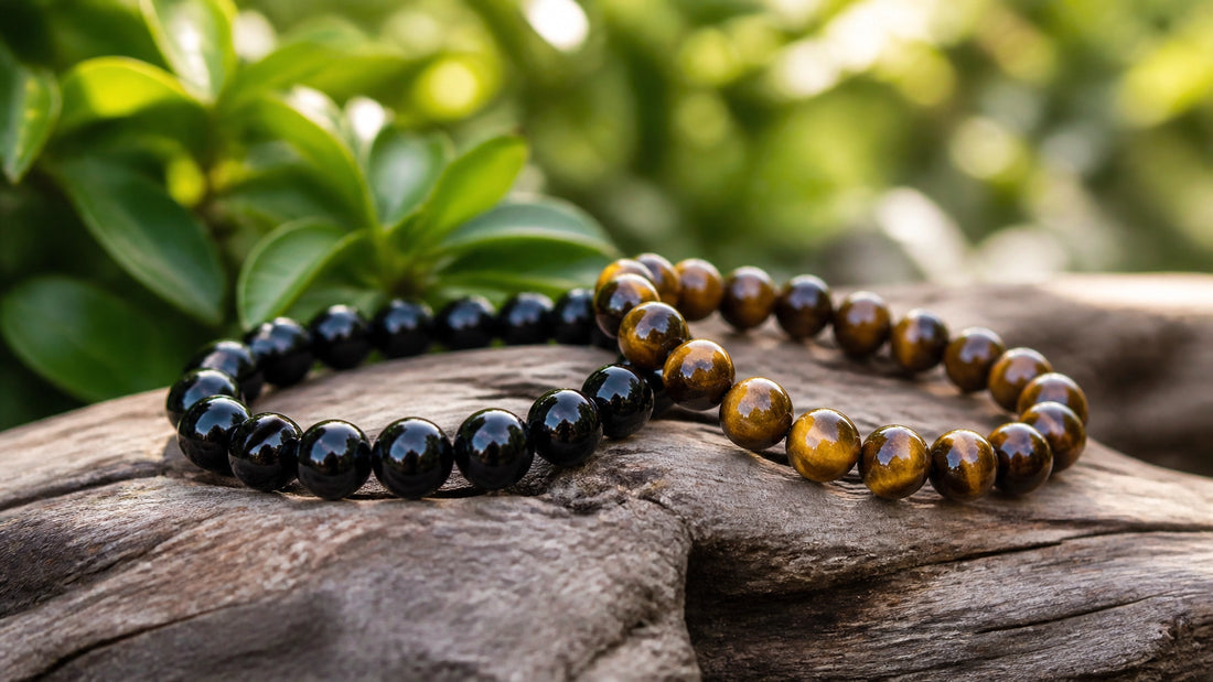 Handmade Black Onyx and Tiger Eye bracelets on a piece of driftwood in a soft-focus garden setting