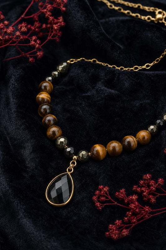 A photorealistic close‑up of a tiger eye and black pyrite necklace laying on a dark velvet background, showing the stone