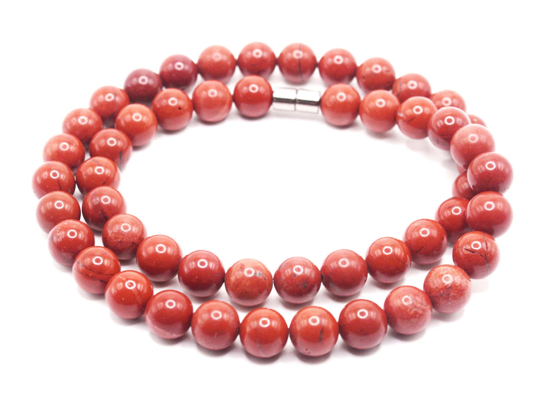 Polished red jasper gemstone necklace with earthy red beads in warm natural light