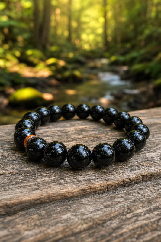 A photorealistic close-up of a smooth black obsidian bracelet on a wooden table, natural light reflecting off the glossy beads, with a soft forest background. Alt: Black obsidian bracelet with shiny volcanic glass beads