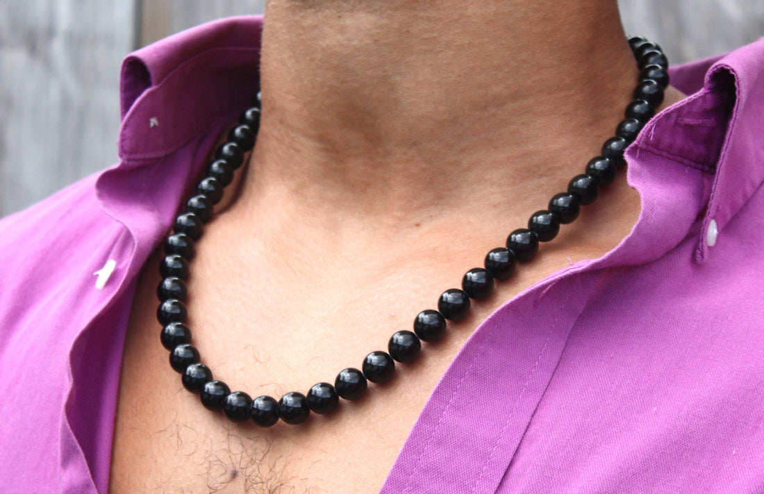 Black tourmaline necklace worn against a purple shirt