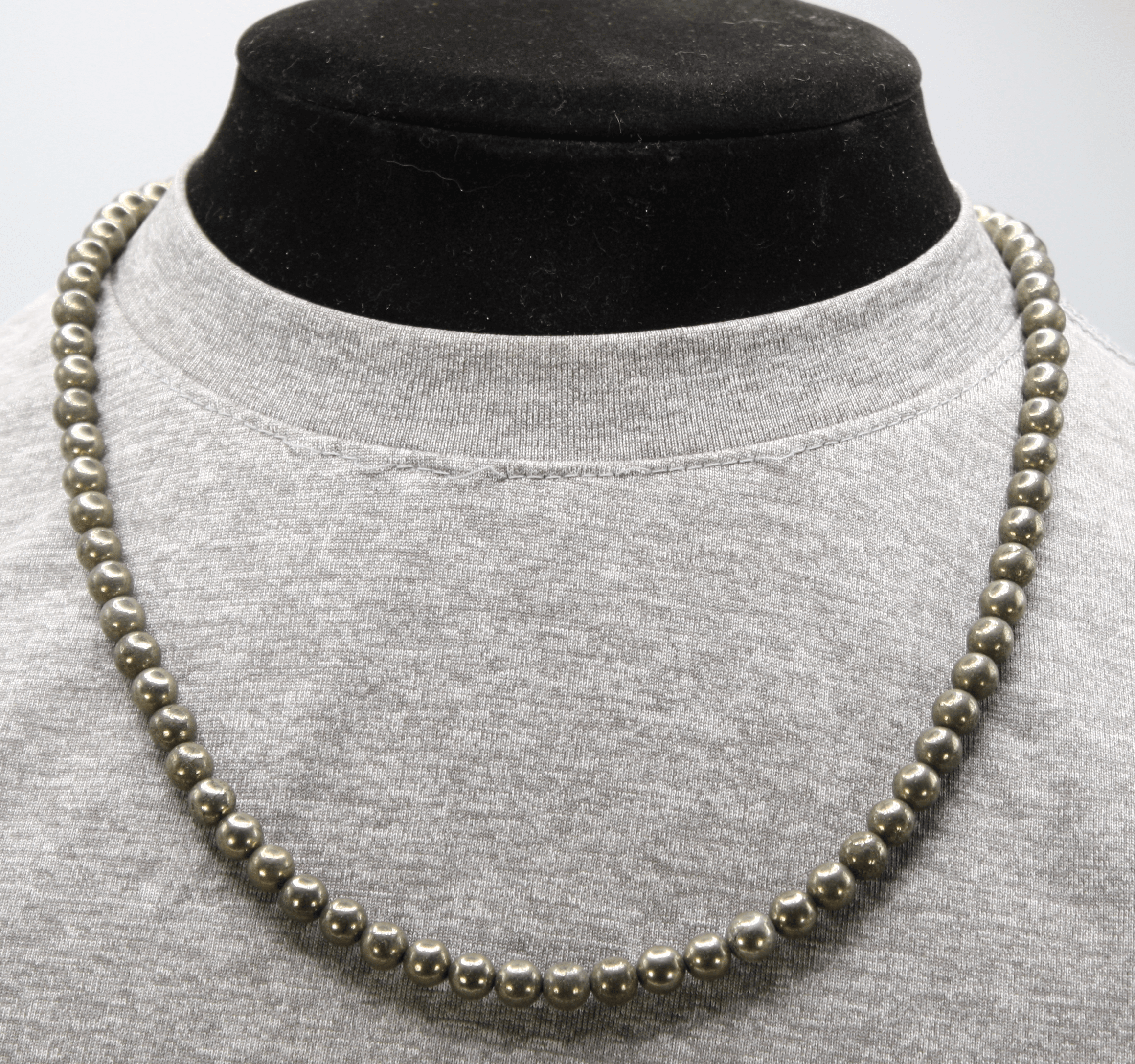 Genuine Pyrite Necklace with 8mm beads displayed on a stand
